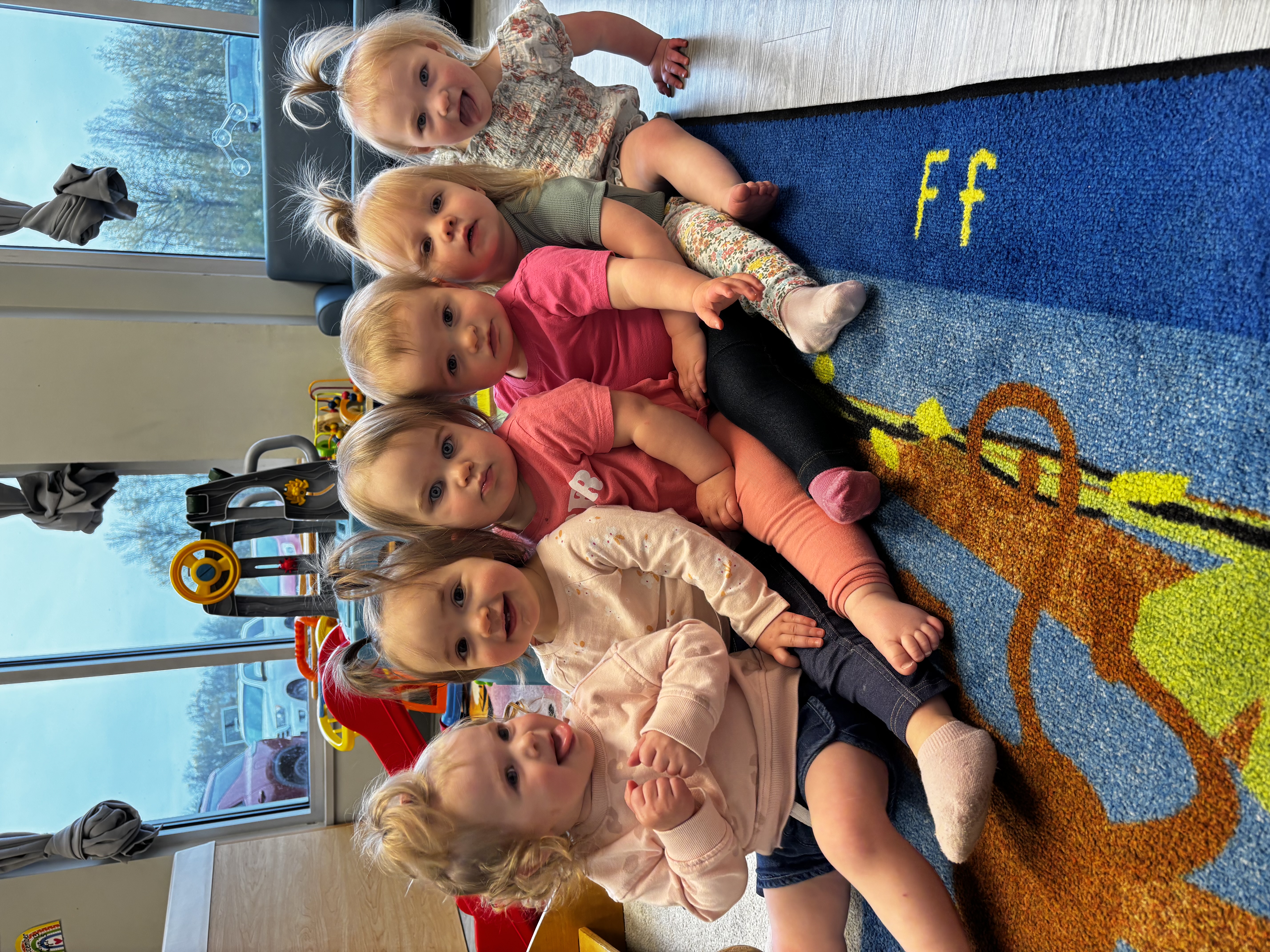 A caregiver cradling a baby in the cozy infant and toddler room at River of Life Daycare